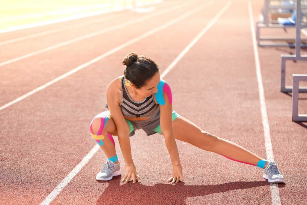 sporty-woman-physio-tape-stretching-stadium